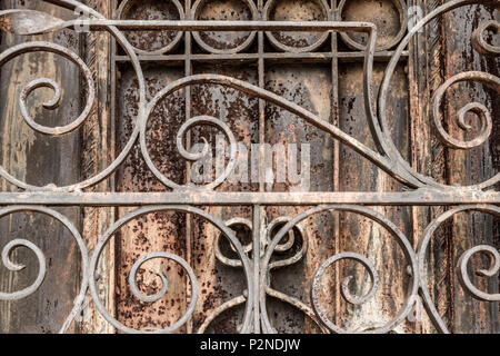 Ornate Rusted wrought iron cemetery gate and door. What the Gate to Hell might look like I Stock Photo