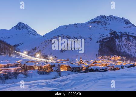 France, Savoie, Val D'Isère, view of the village and Saint Bernard de Menthon Church with a squared Lombard bell tower at dusk and the Olympic flank of Bellevarde (2827 m), massif de la Vanoise, hight Tarentaise valley Stock Photo