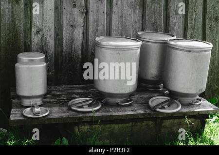 Few drying washed metal milk canisters, churns in the countryside Stock Photo