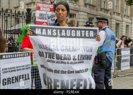 London, UK. 16th June 2018. A Woman holds a placards outside Downing Street during during solidarity march to show support for Grenfell fire victims and families . Credit: Thabo Jaiyesimi/Alamy Live News Stock Photo