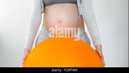 Pregnant woman holding a fitness ball Stock Photo