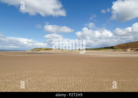 Deserted beach on the North Gower coast with blue skies and white clouds. Stock Photo