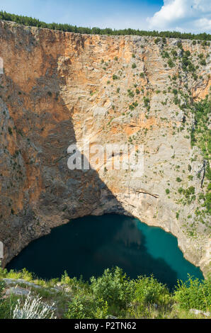 Red Lake Imotski Croatia, Beautiful nature and landscape photo of very big,  deep sinkhole in Dalmatian mountains. Nice sunny summer day. Stock Photo