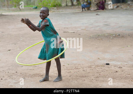A girl uses a hula hoop in the Loreto Primary School in Rumbek, South Sudan. Stock Photo
