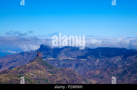 Gran Canaria, June 2018, view acrross Caldera de Tejeda,  rock formation Roque Bentayga to the left, Altavista mountain convered by clouds, Teide on T Stock Photo