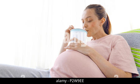 Cheerful pregnant young woman eating ice cream Stock Photo