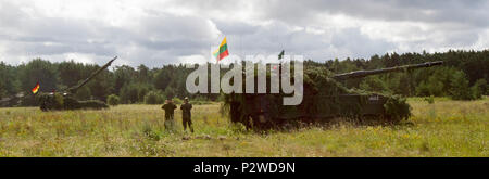 German and Lithuanian Soldiers stand beside a new Lithuanian Howitzer anticipating action from a nearby German Howitzer during Exercise Flaming Thunder, August 2, 2016 at Kairiai, Lithuania. Flaming Thunder is a two-week long multinational fire coordination exercise and combined arms live fire to enhance interoperability among NATO fire support units, and to train and conduct joint fire support with the integration of maneuver elements, close air support, and close combat attack.  The Soldiers from 1st Battalion, 41st Field Artillery Regiment, 1st Armor Brigade Combat Team, 3rd Infantry Divisi Stock Photo