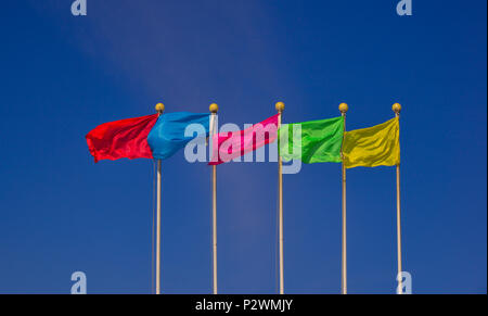Colorful multicolored flags against the blue sky in sunny day. Stock Photo
