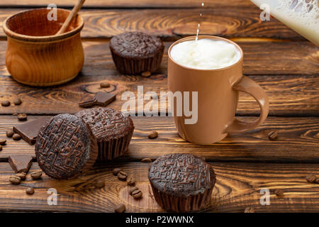 Chocolate muffins with milk on broun wooden background Stock Photo