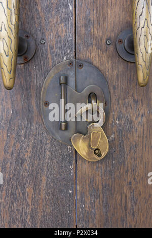Open vintage key on the classic wooden door, room in resort. Stock Photo