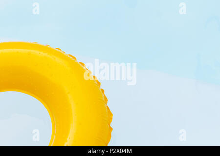 Close up yellow ring floating in refreshing blue swimming pool. Stock Photo