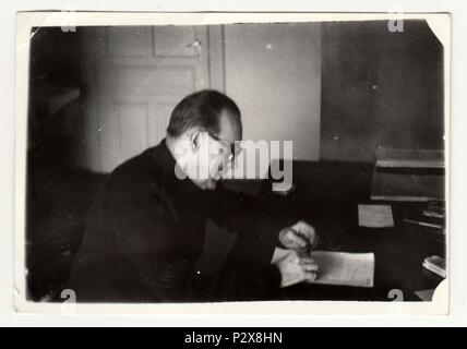 THE CZECHOSLOVAK SOCIALIST REPUBLIC - CIRCA 1960s: Vintage photo shows man sits at the desk. Black & white retro photography. Stock Photo
