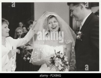 THE CZECHOSLOVAK SOCIALIST REPUBLIC - CIRCA 1980s: Vintage photo shows smiling bride with bridegroom. Happy bride wears  a soft veil and holds wedding flowers (bouquet) . Retro black & white  photography. Stock Photo