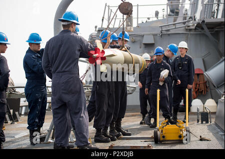 Sailors move an MK 46 MOD 5A torpedo on the aft missile deck ...