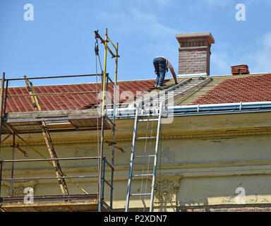 Roofer is working on the roof of a building Stock Photo