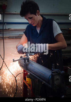 Verona, Italy - July 28, 2017: Use of angular grinder in a metalwork factory. Stock Photo
