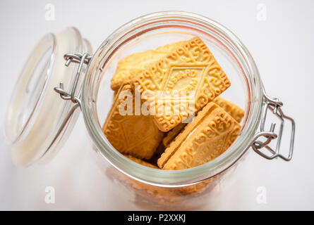 Custard cream biscuits in a glass jar on white background Stock Photo