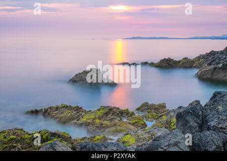 Sun  setting over Rhoscollyn Head on the west coast of Anglesey, Wales,UK Stock Photo