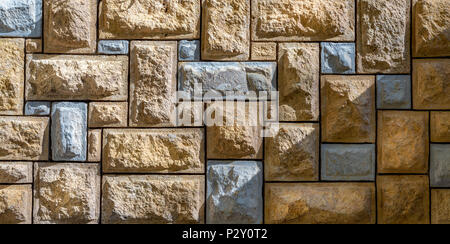 Background of pattern of beige and gray decorative uneven stone wall surface Stock Photo