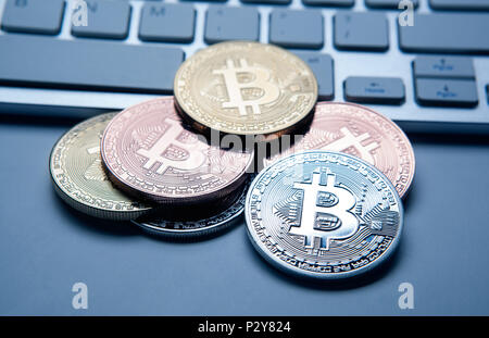 six coins of bitcoin on white laptop pc keyboard closeup Stock Photo