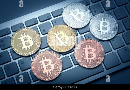 six coins of bitcoin on white laptop pc keyboard closeup Stock Photo