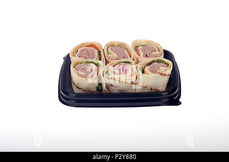 Tray of takeaway pinwheel italian cold cuts deli wrap with cheese, lettuce and tomato isolated on white background Stock Photo