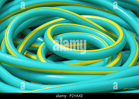 Roll rubber tube in the garden for watering plant Stock Photo - Alamy