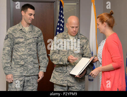 Emily Gilmore, right, Combined Federal Campaign director, presents the CFC Outstanding Achievement Award to Col. Roman L. Hund, center, installation commander, and Tech. Sgt. Justin Morrison, a CFC installation project officer last fall, at Hanscom Air Force Base, Mass., Aug 11. The award was presented to Hanscom AFB by the CFC campaign director for an increase in fundraising during last year's campaign. (U.S. Air Force photo by Linda LaBonte Britt) Stock Photo