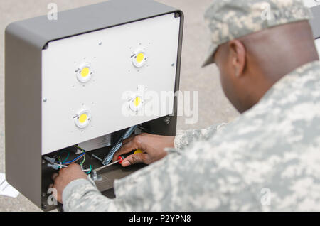 U.S. Army Reserve Sgt. 1st Class Dederrick Morgan, from the 465th Engineer Company, Burmingham, Al., assembles the electrical components for an energy efficient LED street light post during Combat Support Training Exercise (CSTX) 86-16-03 at Fort McCoy, Wis., August 12, 2016. The 84th Training Command’s third and final Combat Support Training Exercise of the year hosted by the 86th Training Division at Fort McCoy, Wis. is a multi-component and joint endeavor aligned with other reserve component exercises. (U.S. Army photo by Spc. Cody Hein/Released) Stock Photo