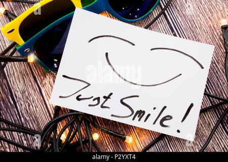 Expression of Just Smile is given in picture. Glasses with two specific shading, lights are spread in different directions. Concept of just smile on f Stock Photo