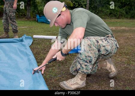 160806-N-CV785-039 KUANTAN, Malaysia (Aug. 6, 2016) Marine Sgt. Zachary Weatherwax, attached to 1st Combat Engineer Battalion, constructs a frame to protect wet concrete at Sekolah Kebangsaan Wira, from seasonal rains. U.S. Navy Seabees worked alongside Malaysian Royal Engineering Regiment soldiers to construct two large play courts for the school children as part of a Pacific Partnership 2016 engineering capability project. This is the first time Pacific Partnership has visited Malaysia. During the mission stop partner nations are working side-by-side with local military and civilian organiza Stock Photo
