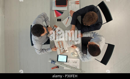 Top view of Colleagues interior designers discussing data with blank screen new modern computer laptop and pro digital tablet with sample material Stock Photo