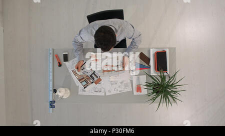 Engineer with blueprints of object and laptop. Top view Stock Photo