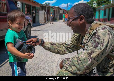 160815-A-CP070-0354 CHOLOMA, Honduras (Aug. 15, 2016) – U.S. Navy Mass Communication Specialist 1st Class, Torrey W. Lee, assigned to Fleet Combat Camera Pacific, lets a local child from Choloma’s Monte Verde village play with his camera during Southern Partnership Station 2016 (SPS-16). SPS-16 is an annual series of U.S. Navy deployments focused on subject matter expert exchanges with partner nation militaries and security forces in Central and South America and the Caribbean. U.S. military teams work with partner nation forces during naval-focused training exercises, military-to-military eng Stock Photo