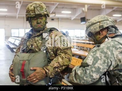 Command Sgt. Maj. Robert Duenas, senior enlisted adviser of 4th Infantry Brigade Combat Team (Airborne) is buddy-rigged by a fellow paratrooper of the 725th Brigade Support Battalion during a training mission on Joint Base Elmendorf-Richardson, Alaska, August 19, 2016. The battalion trained in airfield seizure and water purification as part of the 4th Infantry Brigade Combat Team (Airborne) exercise Spartan Agoge. (U.S. Army photo by Staff Sgt. Daniel Love) Stock Photo