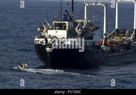 sea aboard USS Lake Champlain (CG 57) Jan. 15, 2002 -- The small boat coxswain maneuvers the Rigid Hull Inflatable Boat (RHIB) to the pilot's ladder to pick up the Vessel Boarding Search and Seizure (VBSS) team from the merchant vessel it has just inspected and bring them back to USS Lake Champlain.  Maritime Interception Operations (MIO) are being conducted by the Stock Photo