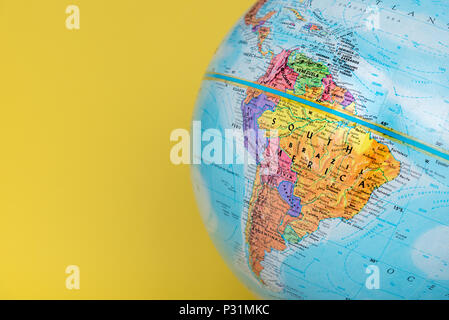 Close-up of South America on globe with solid yellow background Stock Photo