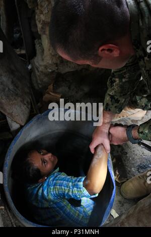 160817-A-CP070-0324 CHOLOMA, Honduras (Aug. 17, 2016) U.S. Navy Hospital Corpsman 1st Class Michael Bigelow, a preventive medicine technician assigned to Naval Environmental Preventive Medicine Unit 2, helps Xenia Caballero, a member of Operation Blessing, out of a well during Southern Partnership Station 2016 (SPS-16). SPS-16 is an annual series of U.S. Navy deployments focused on subject matter expert exchanges with partner nation militaries and security forces in Central and South America and the Caribbean. U.S. military teams work with partner nation forces during naval-focused training ex Stock Photo