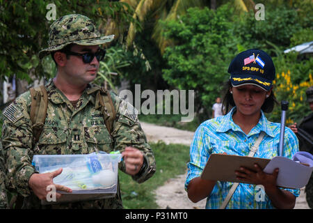 CHOLOMA, Honduras (Aug. 17, 2016) – U.S. Navy Lt. Alister Bryson, an entomologist assigned to Naval Environmental Preventive Medicine Unit 2, looks at Xenia Caballer’s notes during a walk-through of Choloma’s Monte Verde village during Southern Partnership Station 2016 (SPS-16). SPS-16 is an annual series of U.S. Navy deployments focused on subject matter expert exchanges with partner nation militaries and security forces in Central and South America and the Caribbean. U.S. military teams work with partner nation forces during naval-focused training exercises, military-to-military engagements  Stock Photo