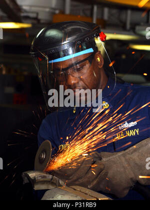 sea aboard USS Theodore Roosevelt (CVN 71) (Jan. 6, 2002) Ð Chief Hull Maintenance Technician (HT) Mervin Stout from the British Virgin Islands, grinds an aircraft tailhook in the HT shop aboard the Roosevelt.  The carrier is operating in support of Operation Enduring Freedom. Stock Photo