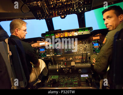 The President of the 2017 Tournament of Roses Parade, Mr. Brad Ratliff and Captain Alejandro Reyes, executive officer, 60th Operations Support Squadron prepare to take off in a C-5M flight simulator, Travis AFB, Calif,. Aug 12, 2016. Other than the standard flight acclamation, the C-5 M flight simulator is used to train aircrew members in situations not normally encountered on the aircraft. Mr. Ratliff was touring the base to learn more about the Travis mission. (U.S. Air Force Photo by Heide Couch) Stock Photo