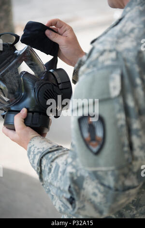 A U.S. Soldier with 650th Military Intelligence Group cleans his M50 joint service general purpose mask, on Chièvres Air Base, in Chièvres, Belgium, Aug. 18, 2016. (U.S. Army photo by Visual Information Specialist Pierre-Etienne Courtejoie) Stock Photo