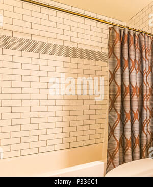 Shower curtain in tiled bathroom of model home in Utah Valley Stock Photo