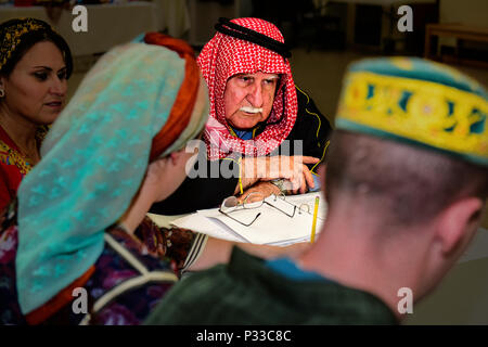 Students in a Full Immersion Arabic program at the Defense Language Institute Foreign Language Center practice interviewing local nationals in Arabic during a training exercise at Ft. Ord, Seaside, California. Students are immersed in the target language for up to three days, permitted only to speak Arabic while engaging with cultural elements, including traditional dress. The exercise develops language proficiency, cultural understanding, interpersonal communication skills, and practical intelligence-gathering techniques for military and diplomatic operations. Stock Photo