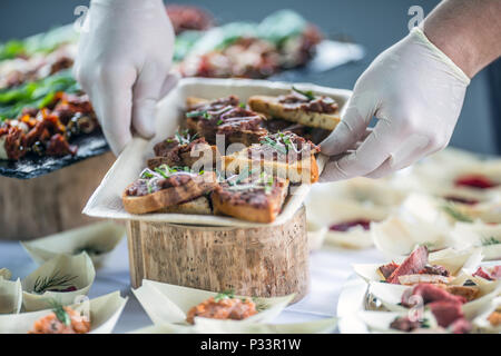 Chef preparing raw beef tartar mini breads on a catering event. Stock Photo