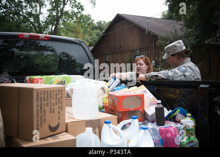 Callie Lips, wife of Tech. Sgt. Ricky Lips, 403rd Maintenance Group, and Master Sgt. Jennifer Simmons, 403rd Wing Inspector General office, load donations into the Lips' truck to help with recovery after their home flooded. Airmen from the 403rd Wing came together to help one another with response and recovery Aug. 19 after flooding in Baton Rouge, Louisiana. (U.S. Air Force photo/Senior Airman Heather Heiney) Stock Photo