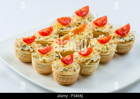 Three baguette slices with liver and apple pate and a thin tomato slice on top. Shallow DOF Stock Photo