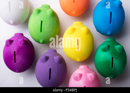 Elevated View Of Multi Colored Piggybanks On White Background Stock Photo