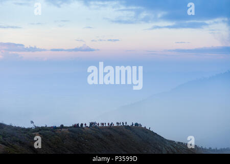 Visitors walk along the rim of the Ijen volcano crater on Java, Indonesia Stock Photo