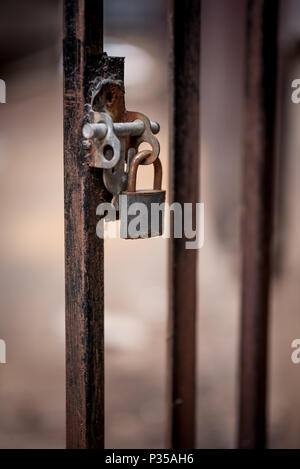 A closeup of a rusty padlock on a metal barred door in Johannesburg CBD Stock Photo